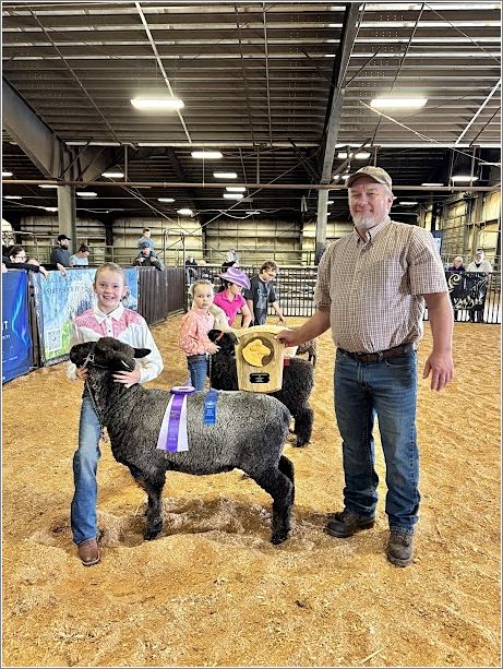 Kerstin Bauer holds her champion medium wool ewe with Judge Gossard. Photo: Denali Bosco.